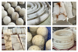 Natural alabaster blocks, rings and carved shades in the workshop, showing varied veining.